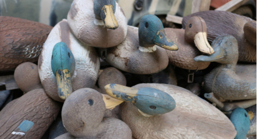 Pile of duck decoys on top of each other.