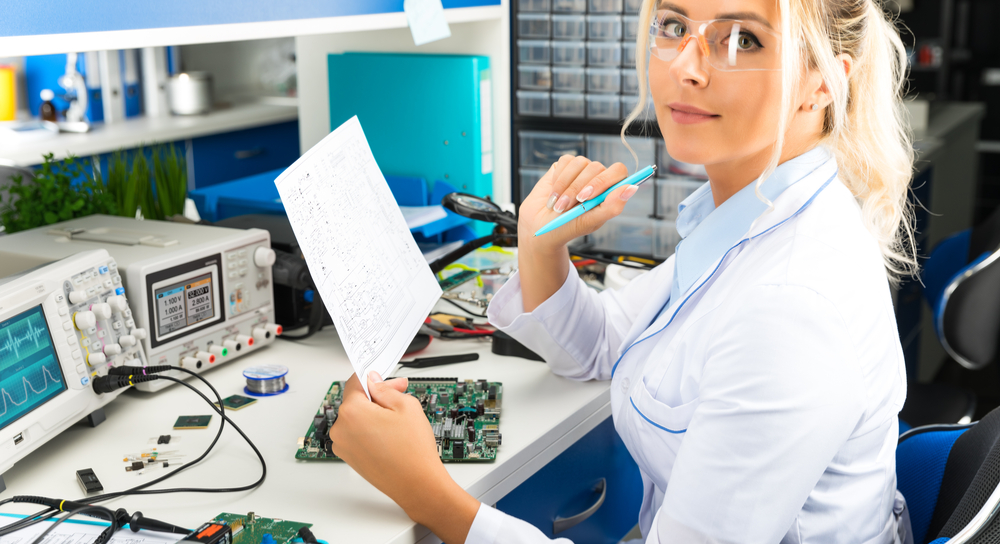 Engineer testing circuit board to schematic