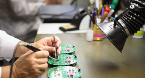Assembler soldering components on a PCB