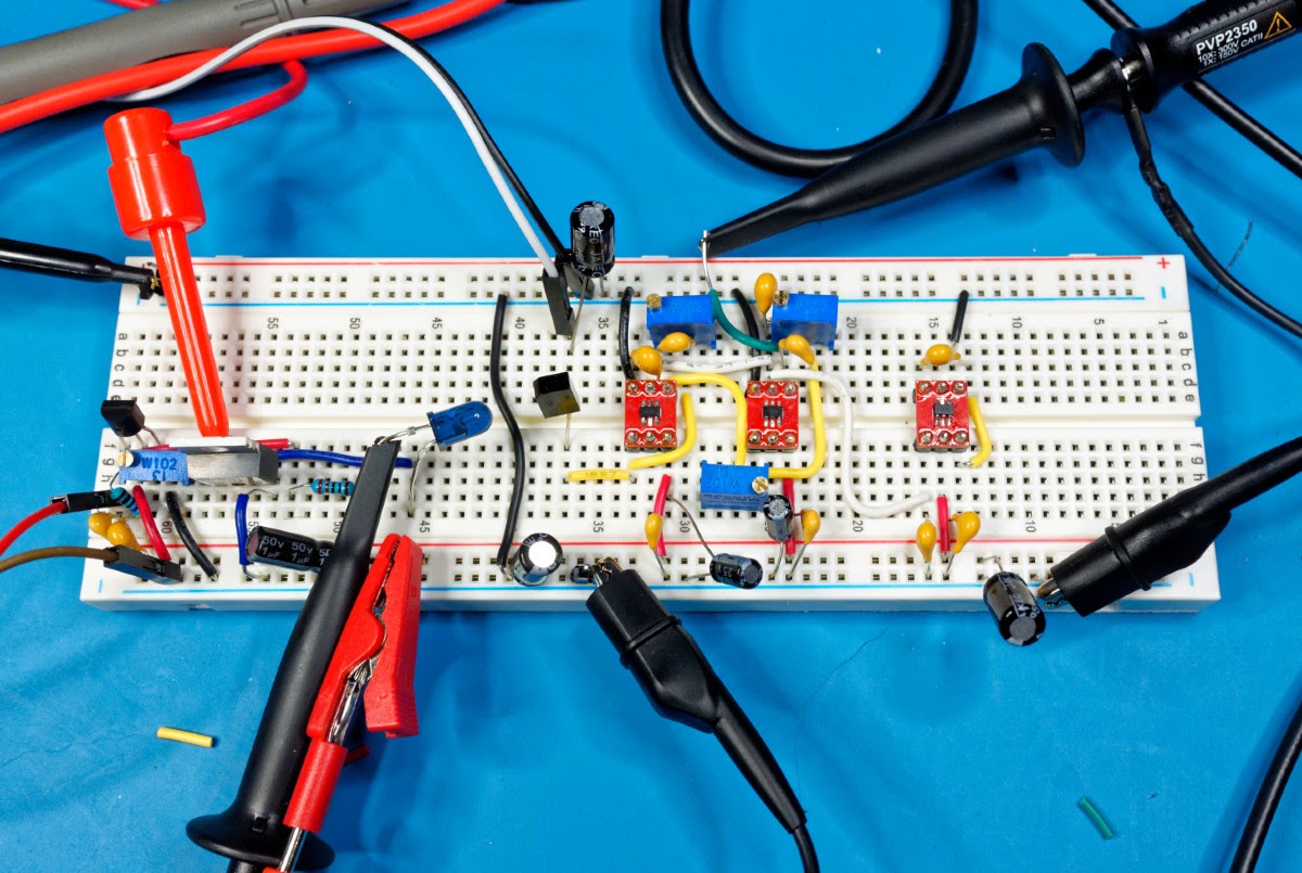 A breadboard with IR components, passive components, breakout op amp boards, and multiple probes connected